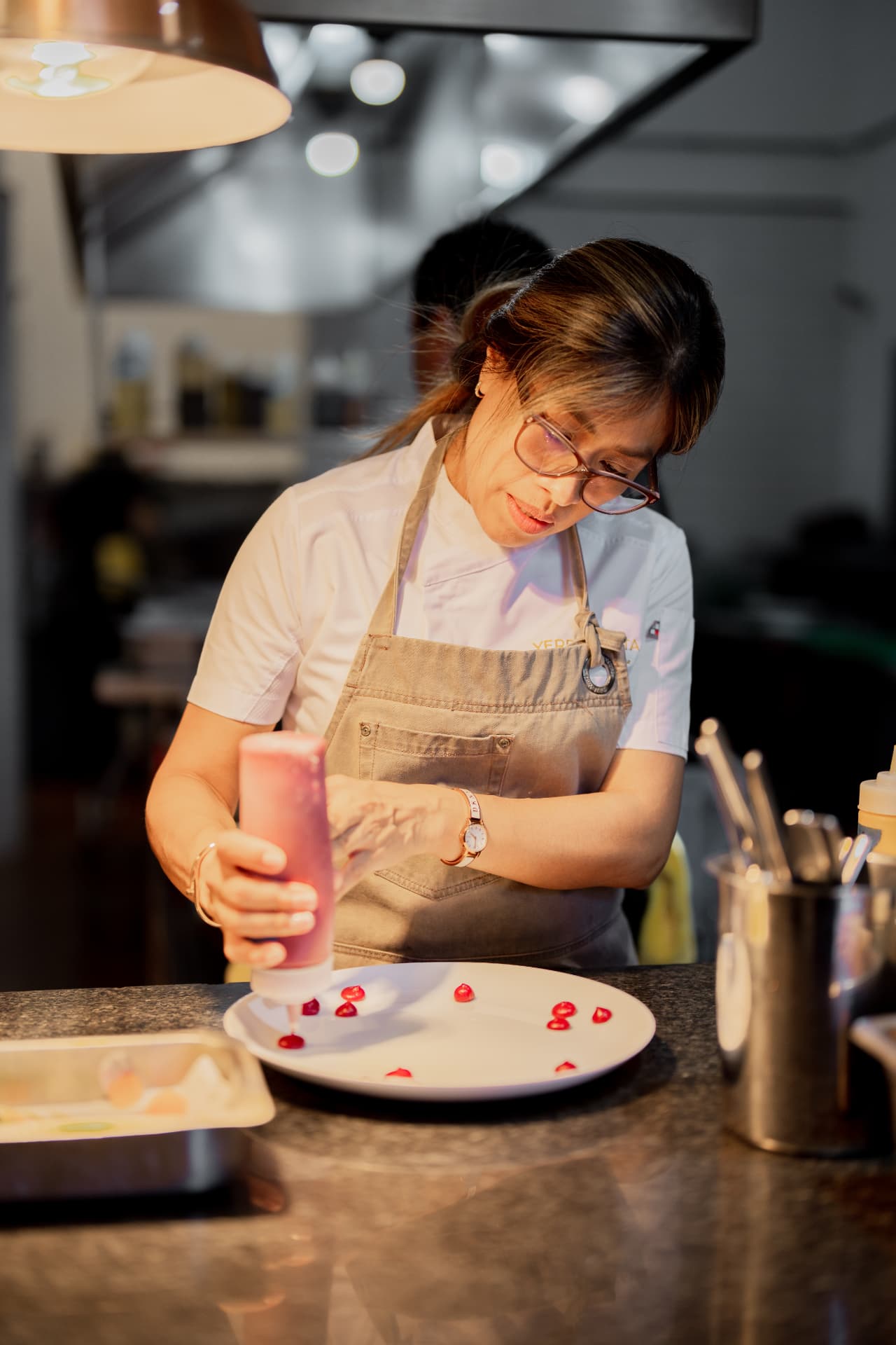La Chef Ejecutiva Nidia Sánchez preparando un platillo en la cocina de Yerba Santa